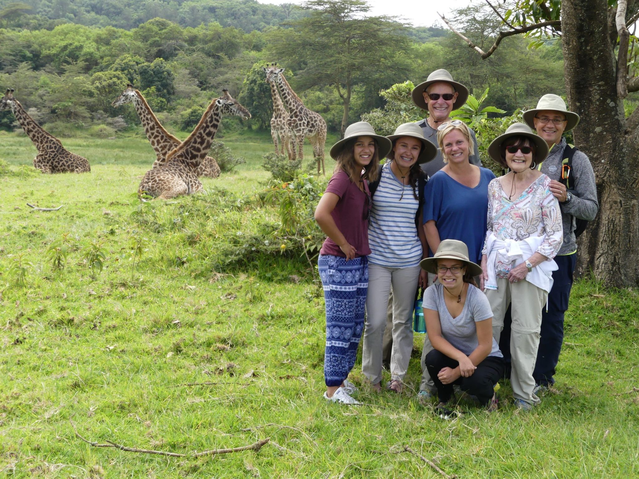 a family taking a photo with giraffes while on a family safari