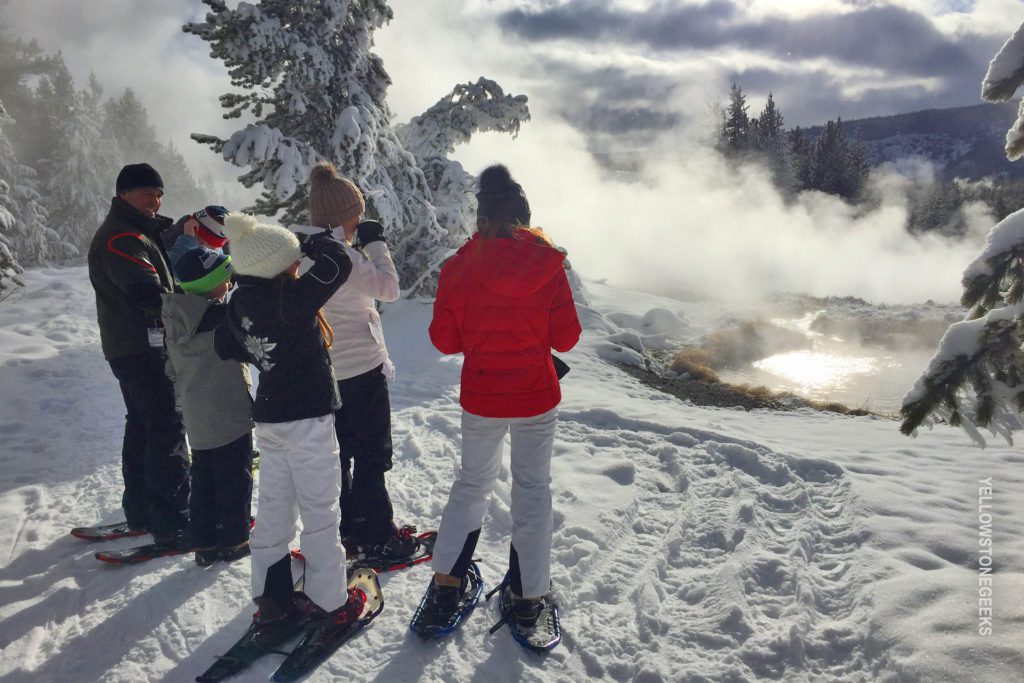 family watches geyser in yellowstone